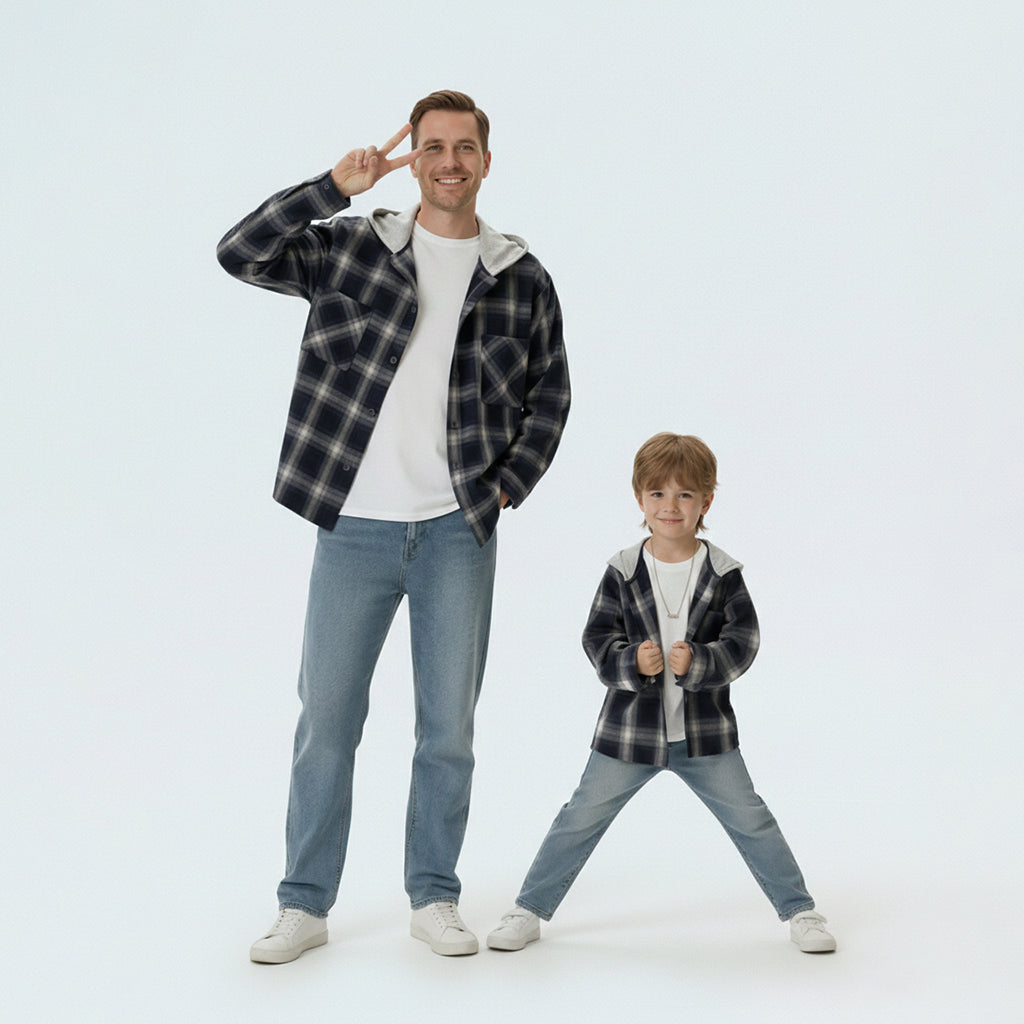 Father and son bonding in matching family outfits, wearing comfortable black and white plaid shirts for a cool day out.