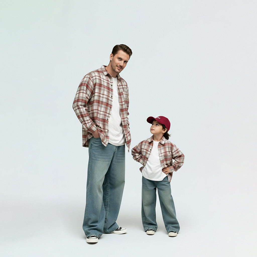 Father and son bonding in matching family outfits, wearing comfortable red plaid shirts for a cool day out.