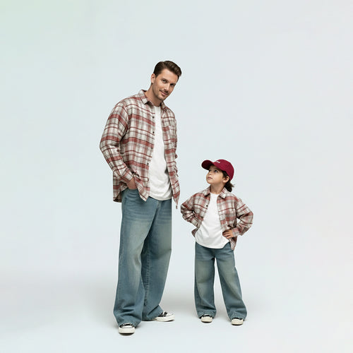 Father and son bonding in matching family outfits, wearing comfortable red plaid shirts for a cool day out.