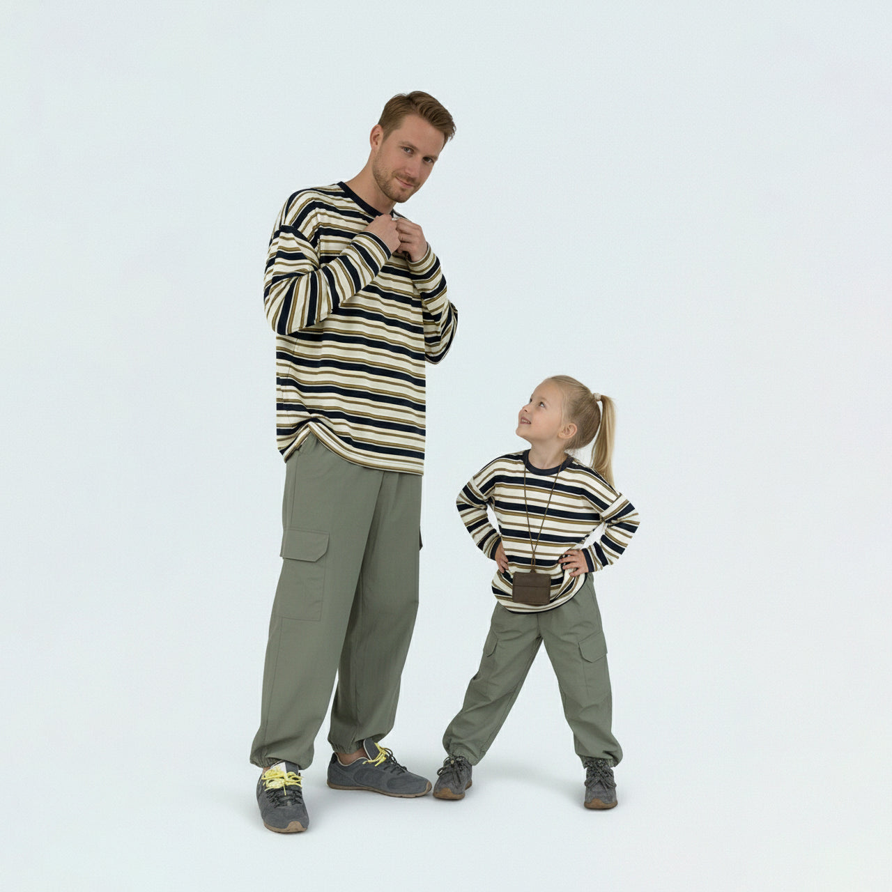 Father and son bonding in matching family outfits, wearing comfortable contrast striped long sleeve shirts.