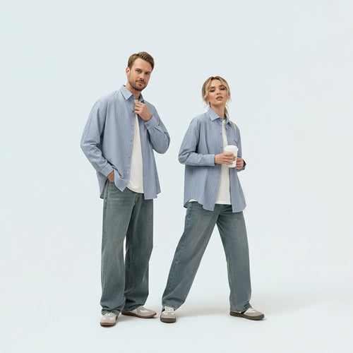 Couple in coordinated matching family outfits featuring the unisex sky blue striped shirt for a relaxed holiday vibe.