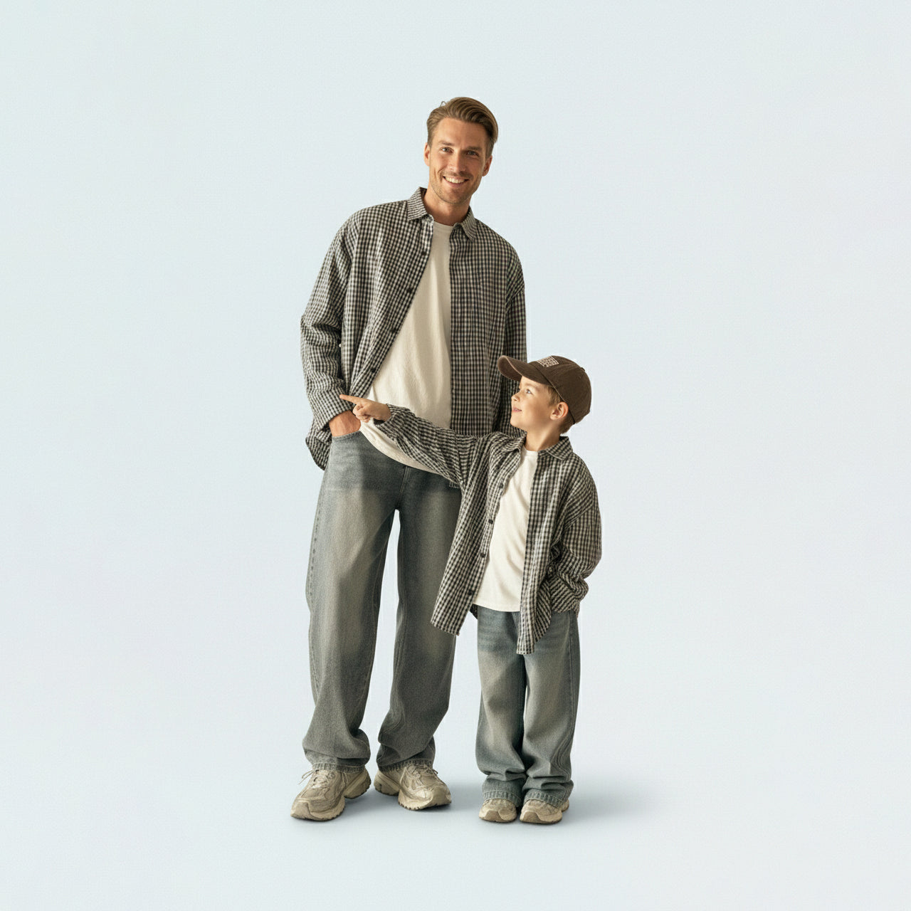 Father and son bonding in matching family outfits, wearing comfortable and breathable grey gingham cotton shirts.