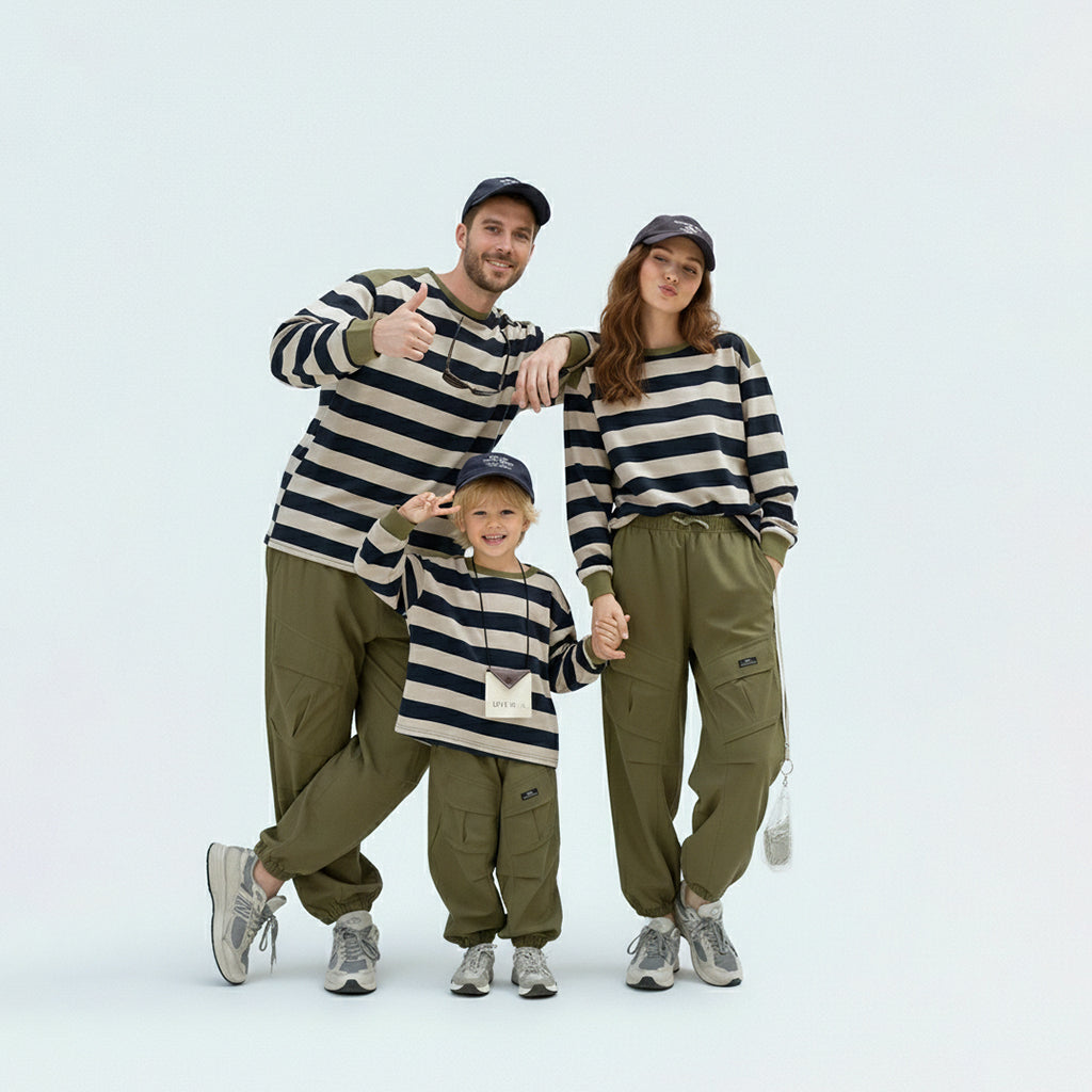 Full family in matching family outfits wearing green striped Japanese style long sleeve tees.
