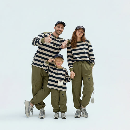 Full family in matching family outfits wearing green striped Japanese style long sleeve tees.