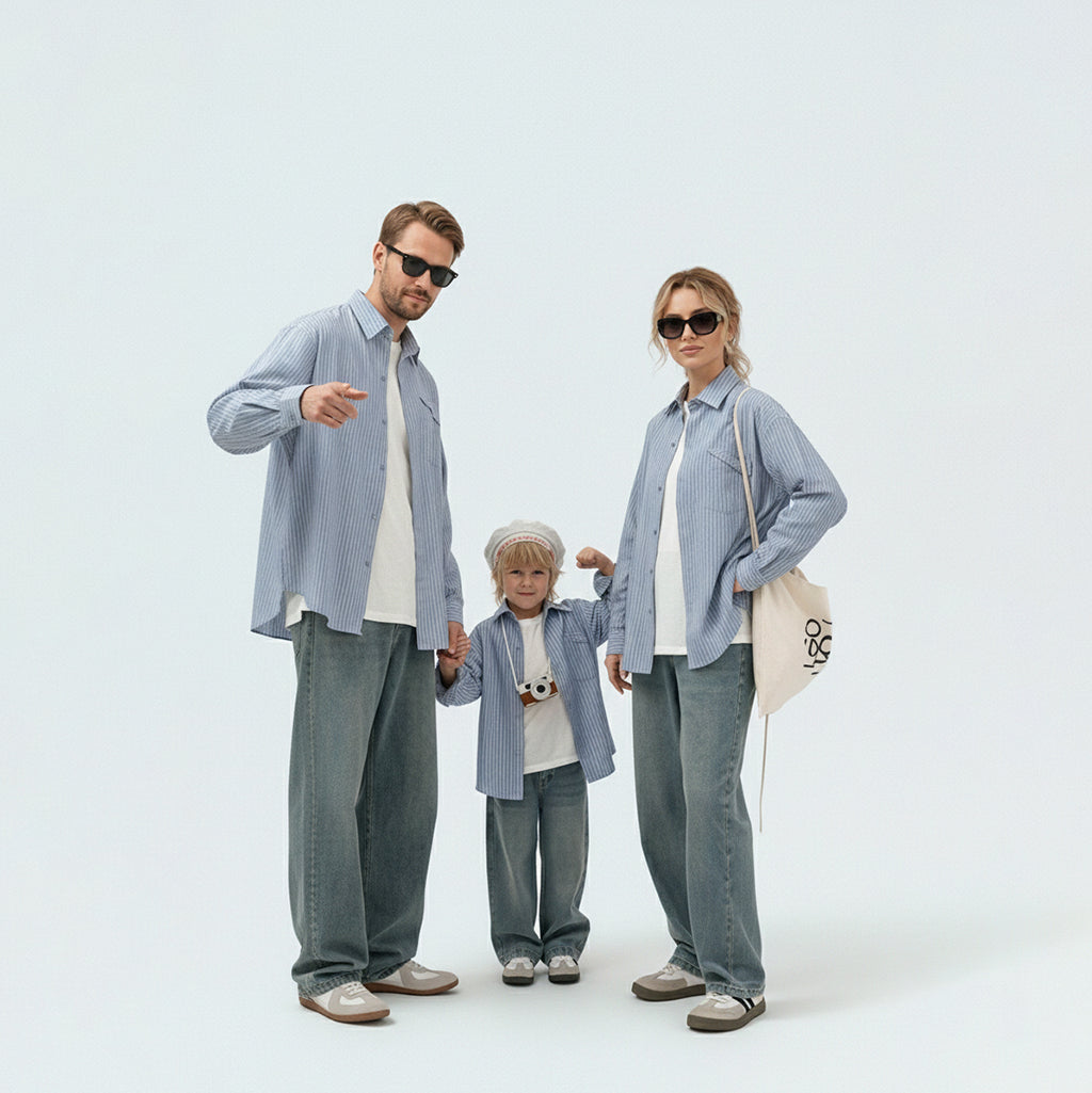 Full family in matching family outfits wearing sky blue striped cotton shirts for a coordinated vacation look.