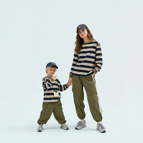 Parents in coordinated matching family outfits featuring the unisex green striped long sleeve tee.